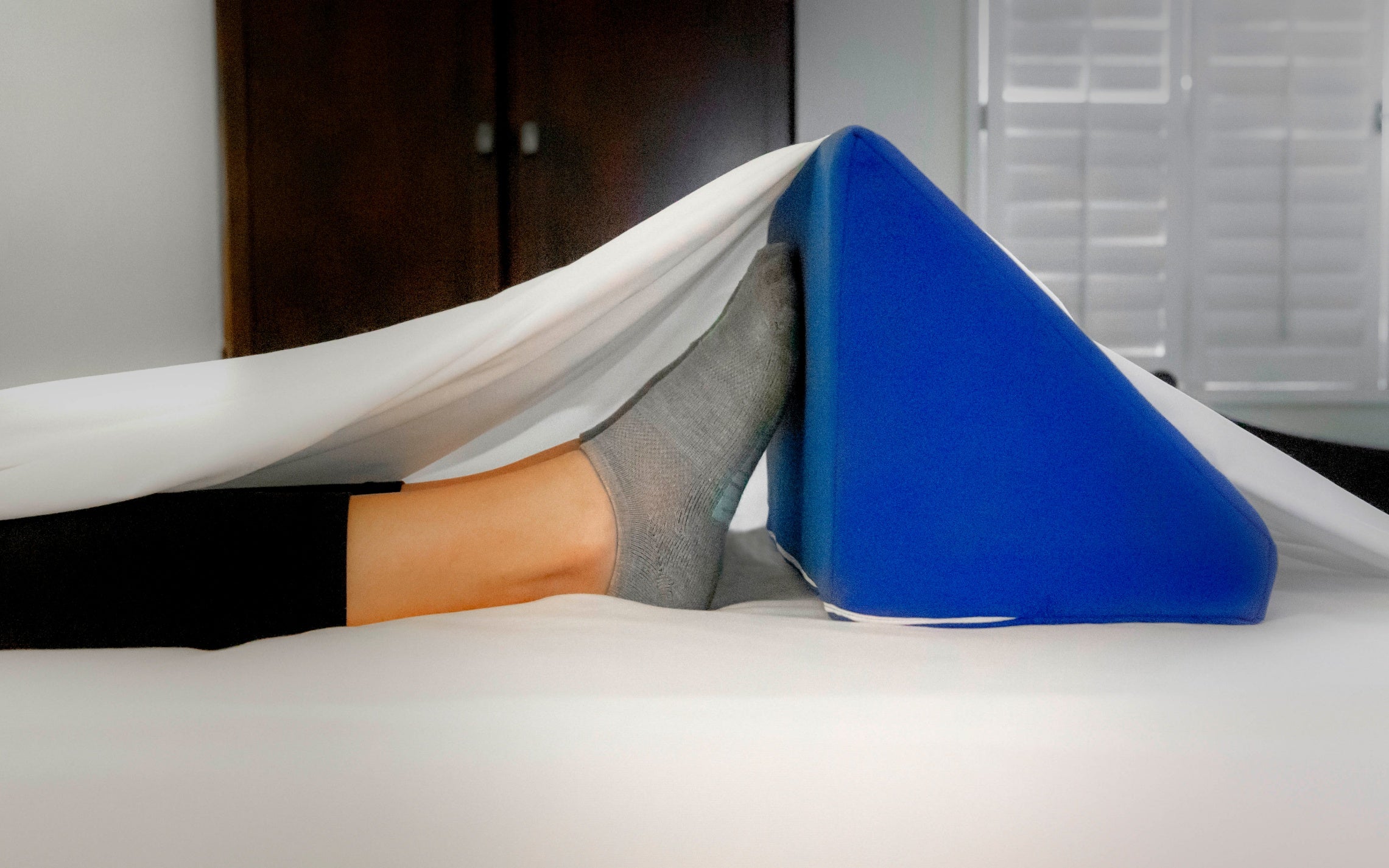 Bed Wedge foot tent blue, lifting sheets above feet to decrease pressure on toes. 